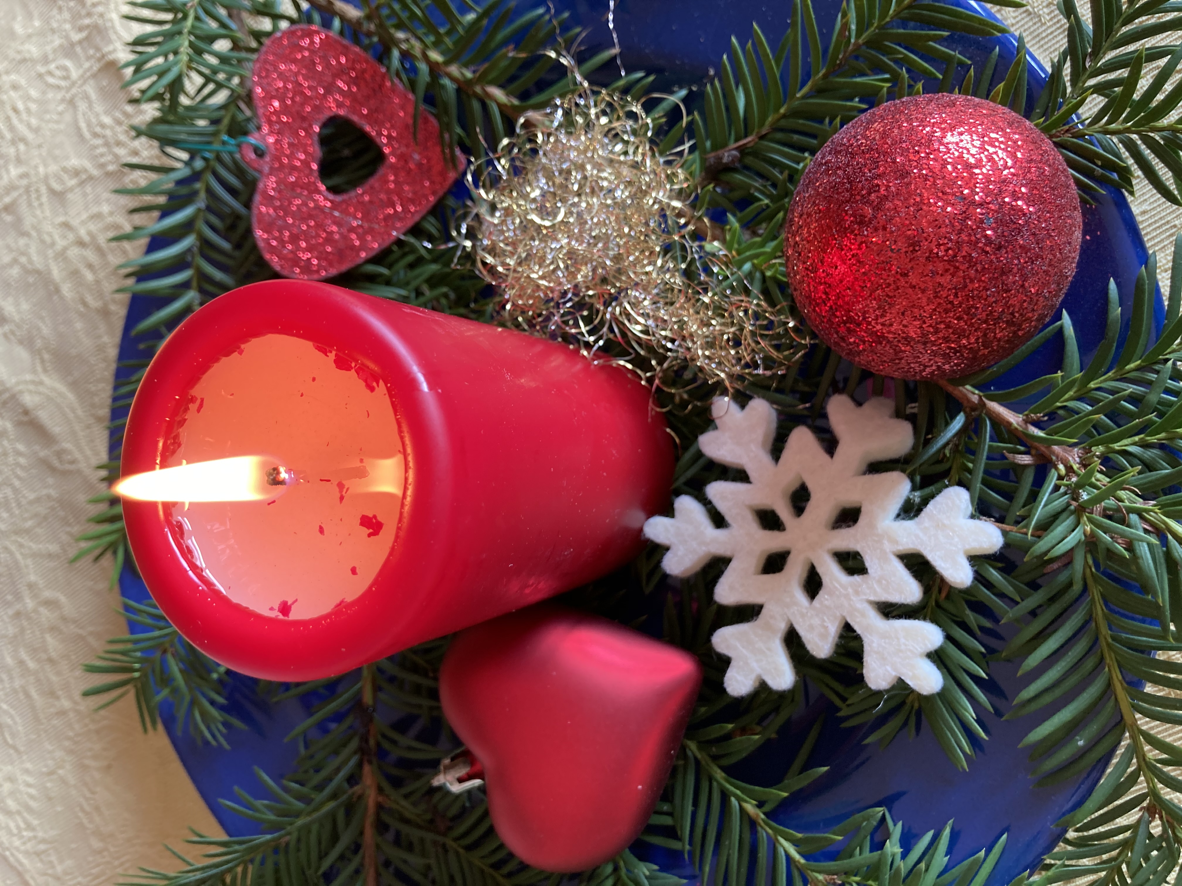 Brennende Kerze in einem Adventsgesteck