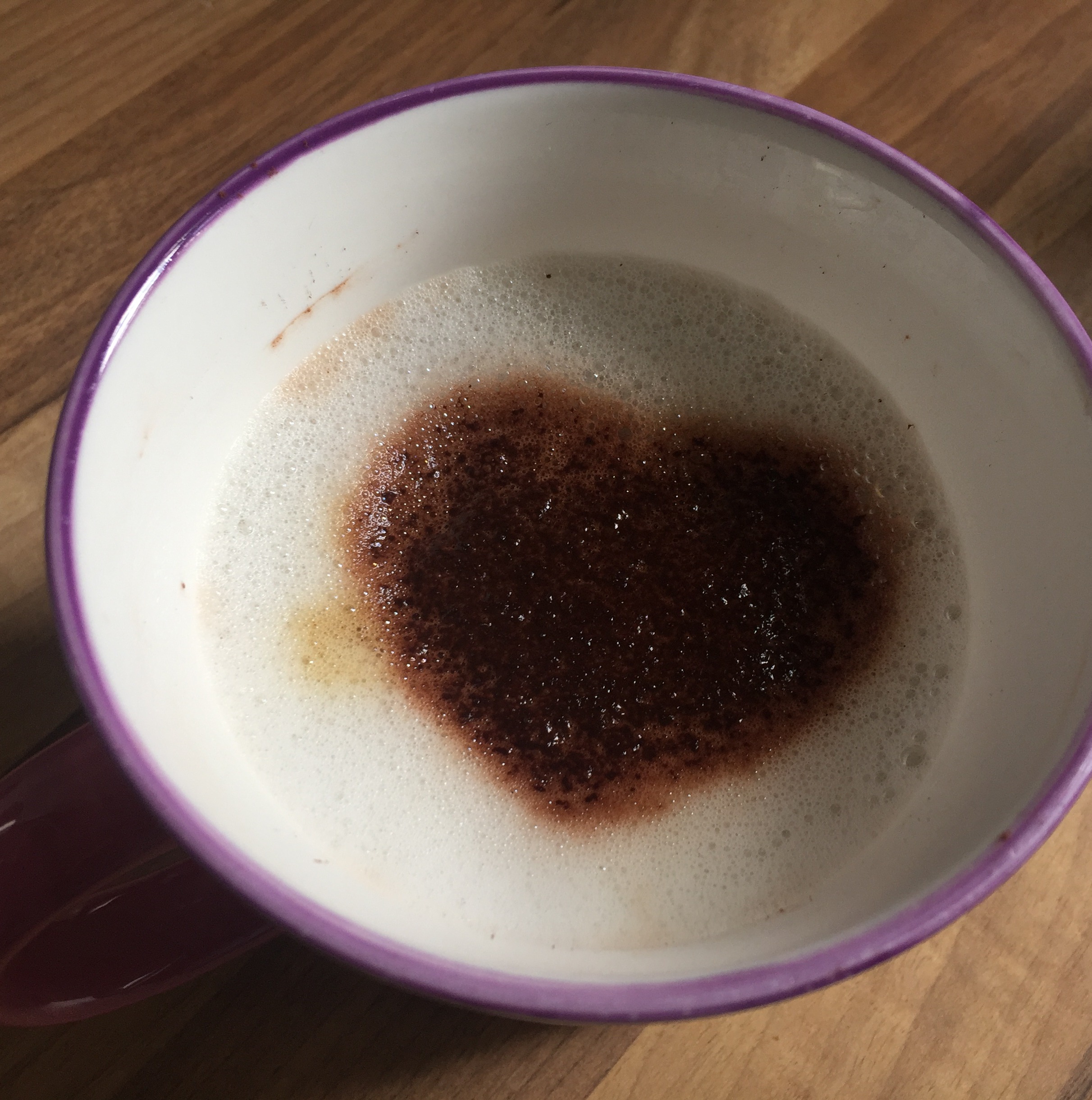 Kaffeetasse mit aufgestreutem Kakaoherz auf dem Milchschaum