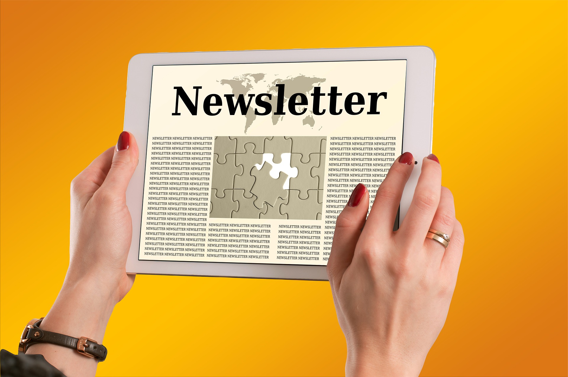 Eine Person hält ein Tablet in die Höhe mit Aufschrift Newsletter
